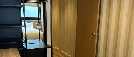 Une chambre d’hôtel avec un lit superposé, un bureau et une armoire.