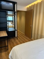 Habitación de hotel con literas, escritorio y armario.