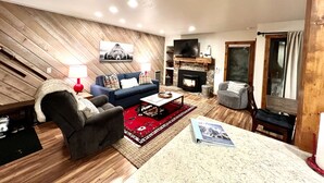 A modern living room with a blue sofa, a fireplace, a television, and a red rug. - Recently remodeled! Close to everything in majestic Snowcreek Resort (Mammoth Lakes)