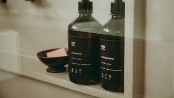 Two bottles of shampoo and conditioner on a shelf.