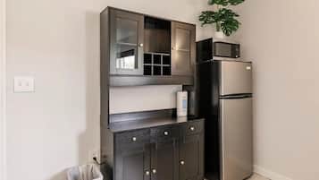 A kitchen with a built-in microwave, a refrigerator, and a cabinet with drawers.