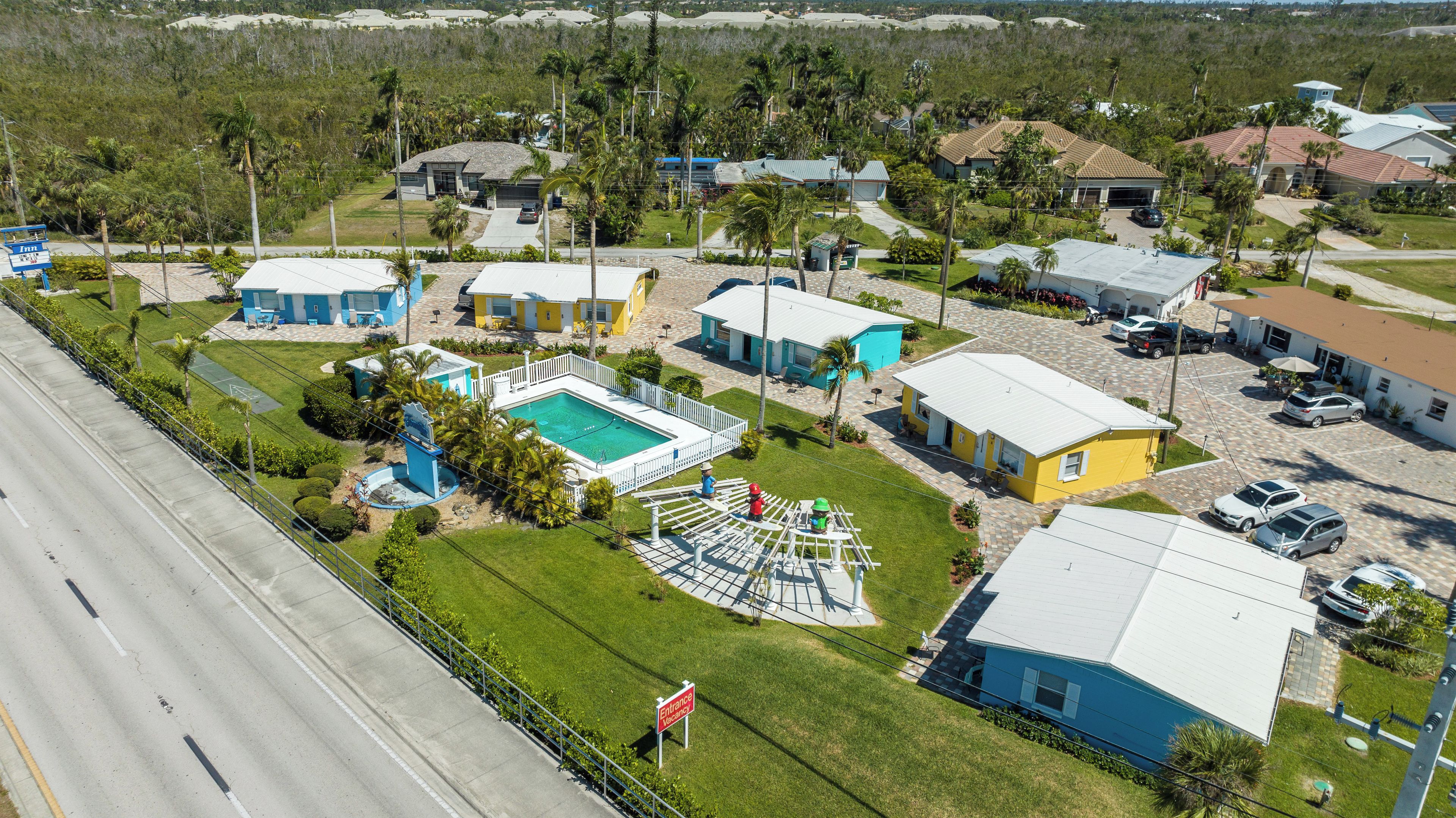 Un quartier résidentiel avec des maisons, une piscine et une route.
