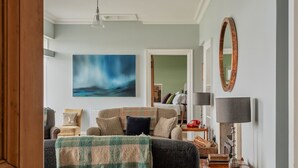 A cozy living room with a sofa, a coffee table, a lamp, and a painting on the wall. - Adventure awaits you on your very own private island off Skye! (Isle of Skye)
