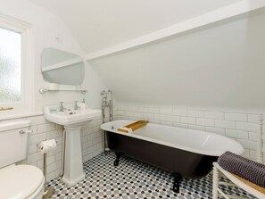 A bathroom with a white sink, a black bathtub, and a toilet. - 3 bedroom accommodation in Selsey (Selsey)