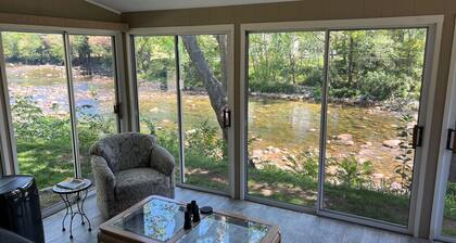 Permanecer en el río Saco al lado de un puente cubierto