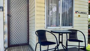 A house with a screened door, a porch with two chairs and a table, and a sign reading "FLORENCE 40B".