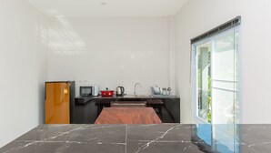 A modern kitchen with a marble countertop, a refrigerator, a sink, and a window with a view of greenery. - Cozy cottage with kitchen of Maenam 4 (Koh Samui)