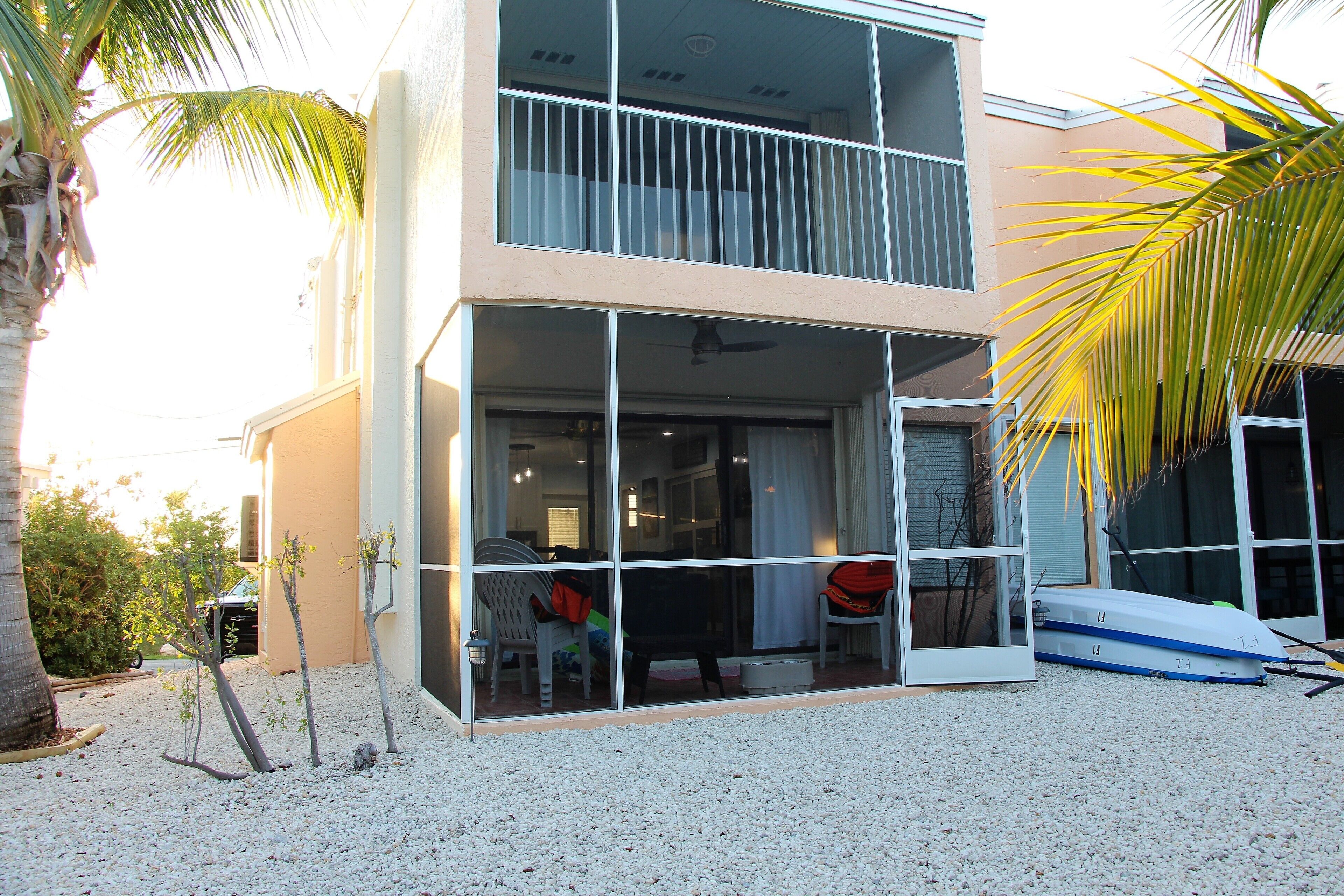A modern two-story building with large glass windows and a balcony.