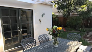 Enjoy a tranquil outdoor space with a table, chairs, and beautiful flowers.