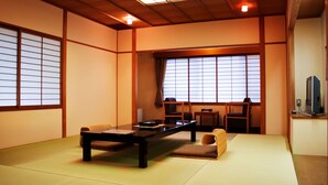 A traditional Japanese-style room with tatami flooring, a low table, chairs, and sliding shoji doors. - Japanese Cuisine Ryokan Koudaiji Yoshinoya (Kyoto)