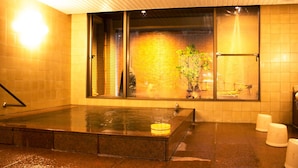 A spa area with a hot tub, a window with a view of a building, and a potted plant. - Japanese Cuisine Ryokan Koudaiji Yoshinoya (Kyoto)