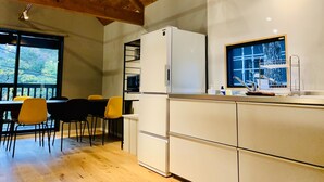 Une cuisine moderne avec un réfrigérateur blanc, un four encastré et une fenêtre au-dessus de l’évier.