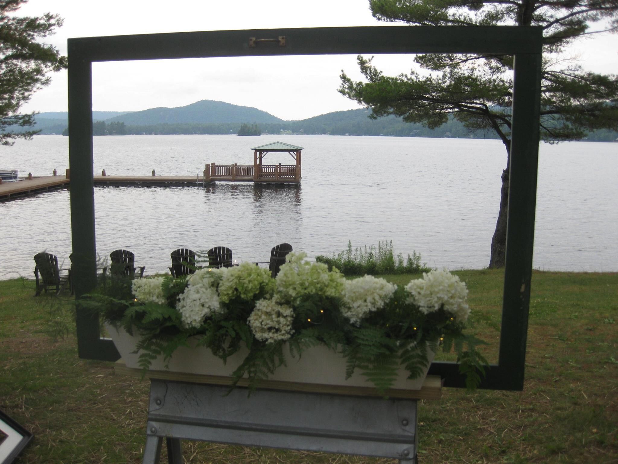A lakeside view with a wooden dock and a gazebo.