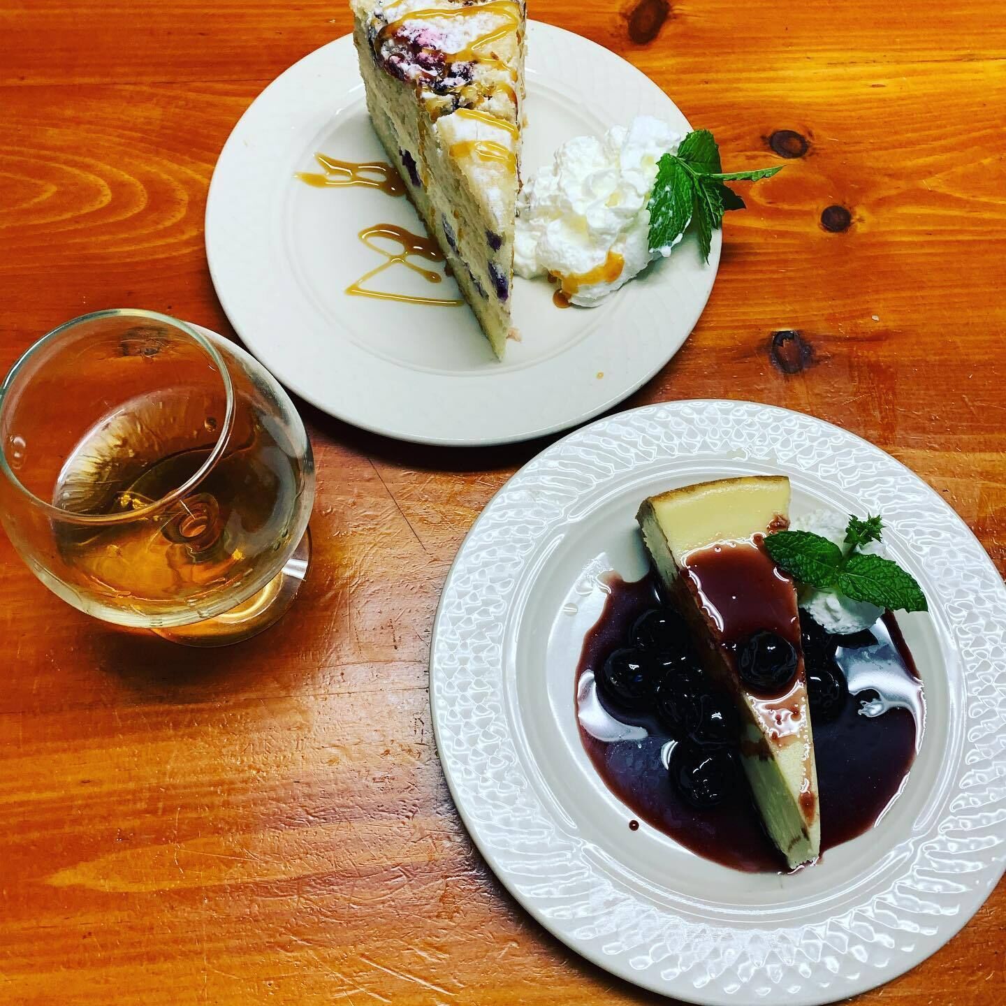 Two plates of dessert on a wooden table.
