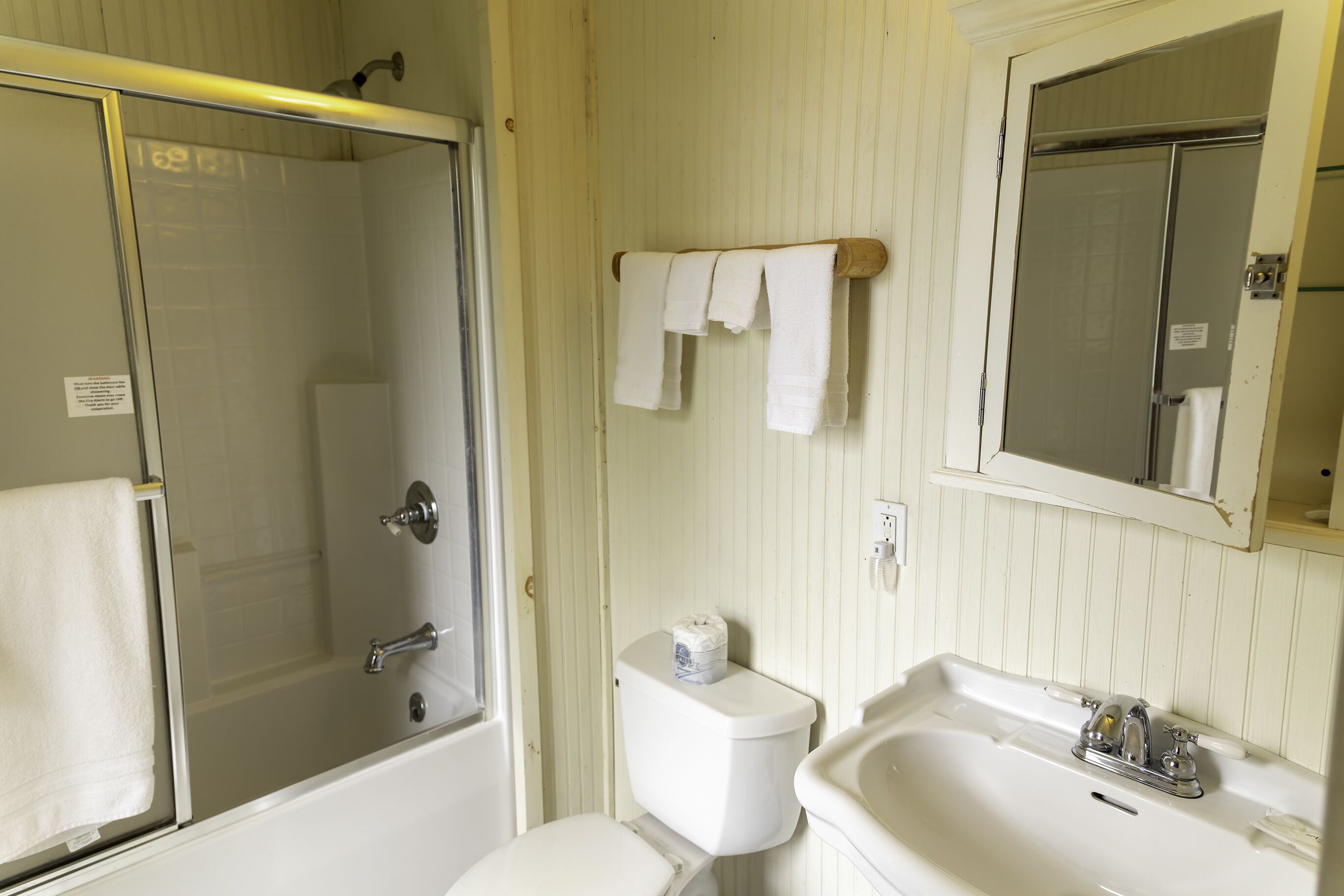 Une salle de bain équipée d’une douche, de toilettes, d’un lavabo et d’un miroir.
