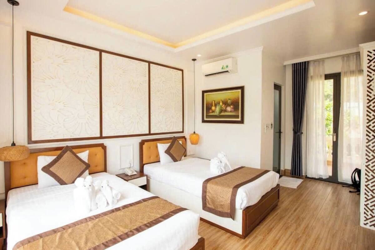 Une chambre d’hôtel avec deux lits, un grand panneau décoratif au mur, un appareil de climatisation et un tableau.