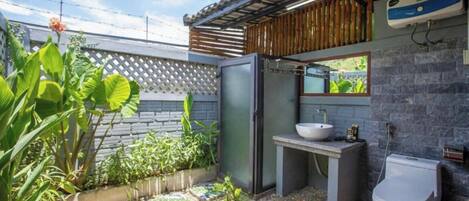 A compact bathroom with a built-in sink, a toilet, and a small window.