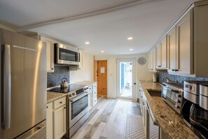 Una cucina moderna con elettrodomestici in acciaio inossidabile, un forno a microonde e un grande forno.
