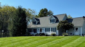 A two-story house with a front porch, a covered entryway, and a well-maintained lawn.