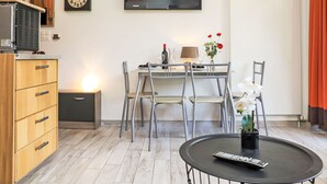 A modern living room with a dining area, a flat-screen TV, a wooden cabinet, and a clock on the wall. - Rosablanche C32 by Interhome (Siviez-Nendaz)