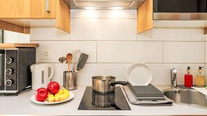 A modern kitchen with a built-in oven, a coffee maker, a kettle, and a variety of kitchen utensils. - Rosablanche C32 by Interhome (Siviez-Nendaz)