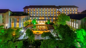 Ein Hotel mit Innenhof, mehreren Etagen und beleuchteten Fenstern.