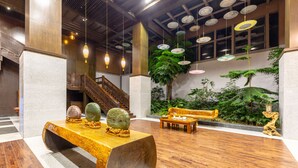 Eine Lobby mit einer hölzernen Bank, einer Treppe und Pendelleuchten.