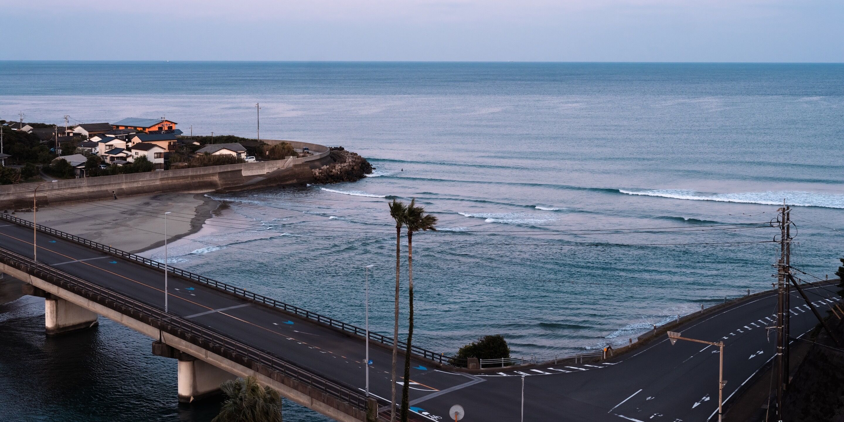 Uma estrada costeira com uma ponte, praia e oceano.