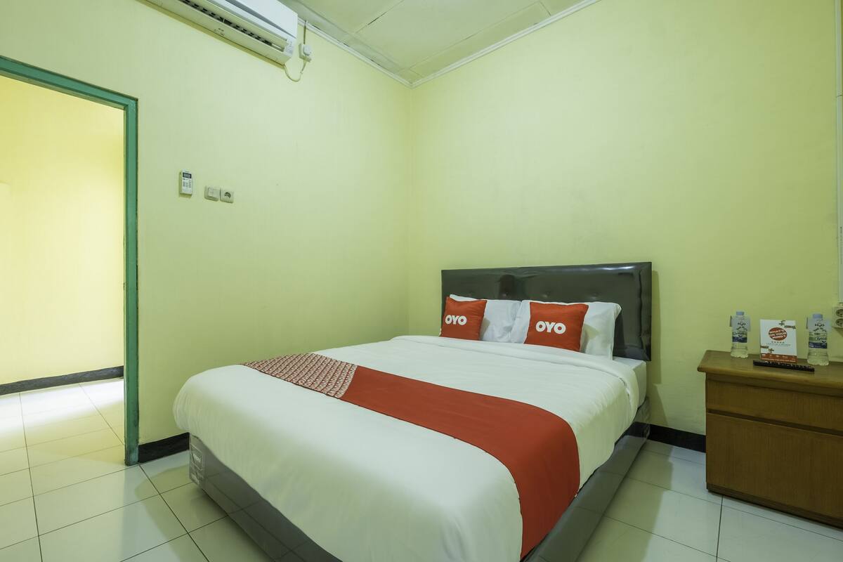 Ein Hotelzimmer mit Bett, Nachttisch und Tür.