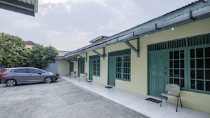 A building with a tiled exterior, a parked car, and a bench.