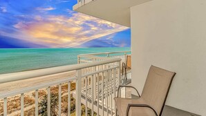Un balcon avec vue sur l’océan et un ciel dégagé.