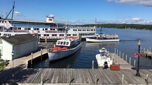 A dock with several boats, including a large white ferry with "WASHINGTON" written on it, and a smaller boat docked nearby. - Weirs Beach - PRIME LOCATION!!!  (Weirs Beach)