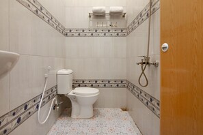 Un baño pequeño con un inodoro, ducha y toallero.