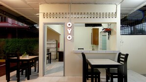 Een modern interieur met een eethoek, bestaande uit een tafel met stoelen, een kleine plant op de tafel en een spiegel aan de muur.