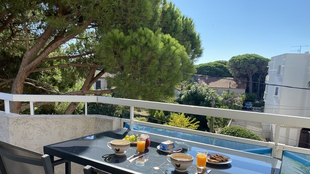 A balcony with a table set for breakfast, overlooking a pool and a residential area. - APARTMENT T3 - Private parking - 300 m SEA & BEACH (Fréjus)