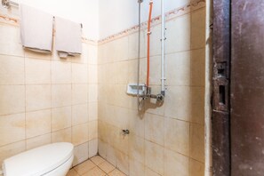 Ein kleines Badezimmer mit Toilette, Dusche und Fliesen.