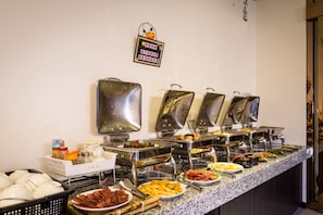 A buffet with various food items and utensils.