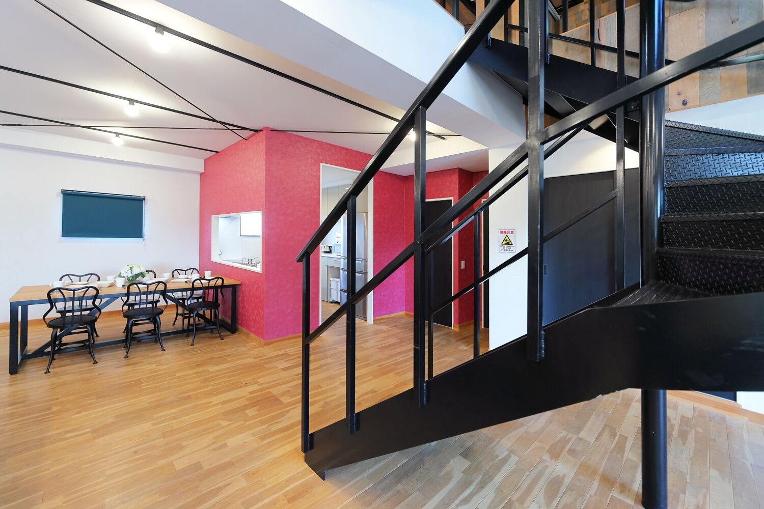 Un interior moderno con comedor, escalera y cocina.