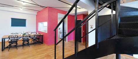 Un interior moderno con comedor, escalera y cocina.