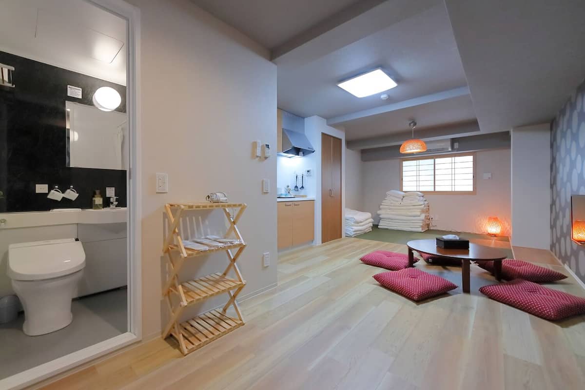 Une chambre d’hôtel moderne dotée d’une salle de bain, d’un coin repas et d’une cuisine.