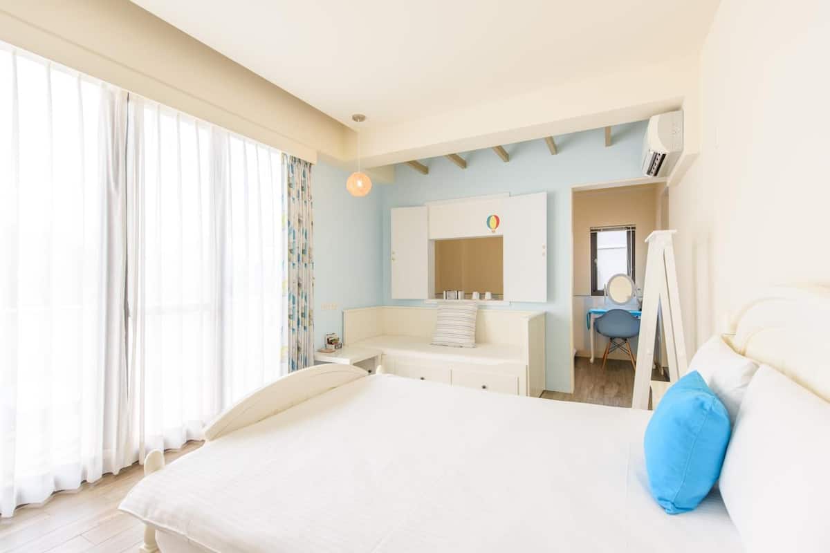 Un dormitorio con una cama, un escritorio y una silla.