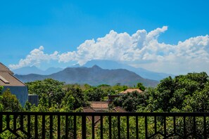 A residential area with houses, lush greenery, and mountains in the background. - Hotel O Family Residence (Kediri)