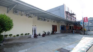 A building with a covered entrance, outdoor seating area, and a signboard. - OYO 1335 Anie 71 Residence (Bengkulu)
