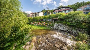 Un quartier résidentiel avec un petit ruisseau, un mur de pierres et des maisons dotées de balcons.