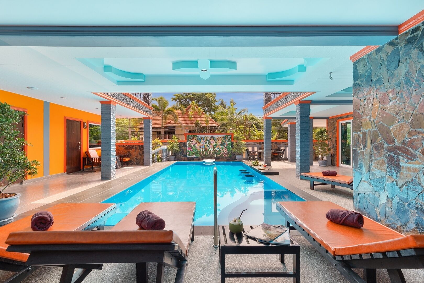 Un área de piscina con sillones de descanso y un mural.