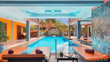 Un área de piscina con sillones de descanso y un mural.