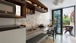 Una cocina moderna con microondas integrado, un lavamanos y una zona de comedor con mesa y sillas.
