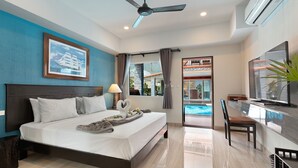 Habitación de hotel con cama, televisión, escritorio y vista a una piscina.