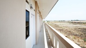 A balcony with a view of a dry, open landscape. - SPOT ON 2027 Putri Guest House Syariah (Cimohong)