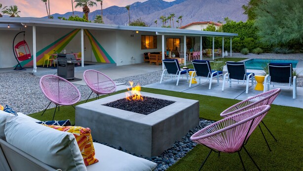 A modern outdoor patio with a fire pit, lounge chairs, and a pool. - Belding Bliss (Palm Springs)